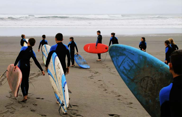 grupo de campamento practicando surf en playa los quebrantos